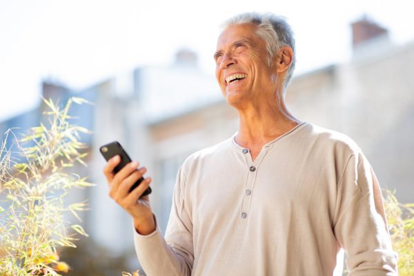 handsome-older-man-laughing-with-mobile-phone-2024-10-12-12-50-15-utc